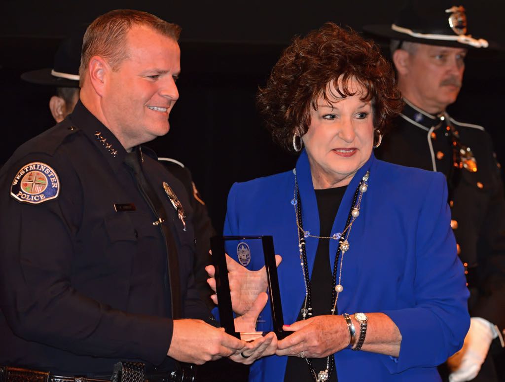 Laura Dela is recognized by Westminster Police Chief Kevin Baker as the 2014 Volunteer of the Year, one of two, during the 2014 Westminster PD Awards Ceremony. Photo by Steven Georges/Behind the Badge OC