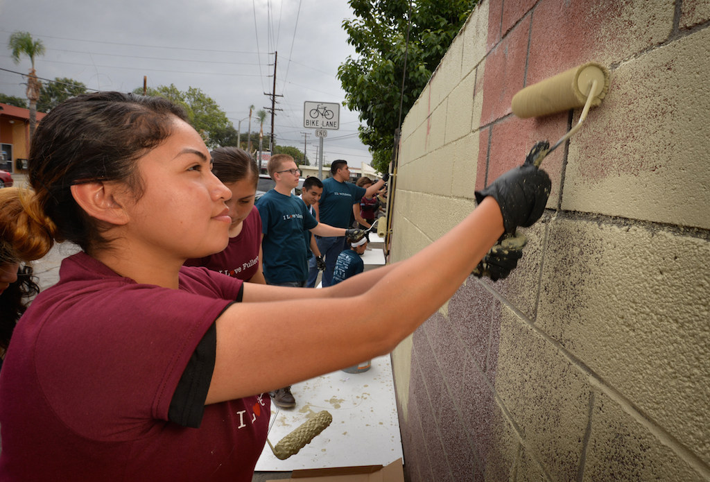 Morales Janeli, 18, of the Sunburst Youth Challenge Academy helps her fellow academy members paint a wall on Valencia Dr. during the second annual Love Fullerton community volunteer event. Photo by Steven Georges/Behind the Badge OC