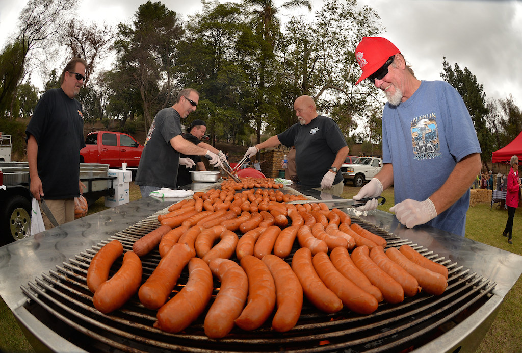 Lance Merrill of Heroes Bar & Grill, right, helps grill sausages at Hillcrest Park in Fullerton as part of a free lunch for volunteers who participated in the second annual Love Fullerton community volunteer event. Photo by Steven Georges/Behind the Badge OC