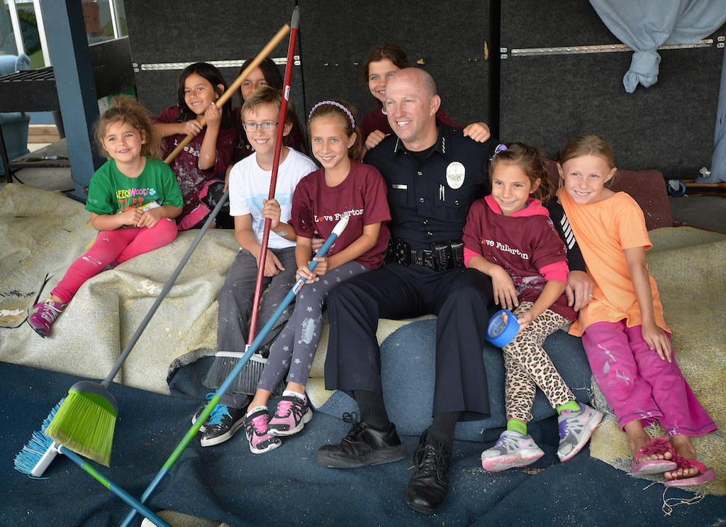 Fullerton Police Chief Dan Hughes sits with kids helping out for a group photo during the second annual Love Fullerton community volunteer event. Photo by Steven Georges/Behind the Badge OC