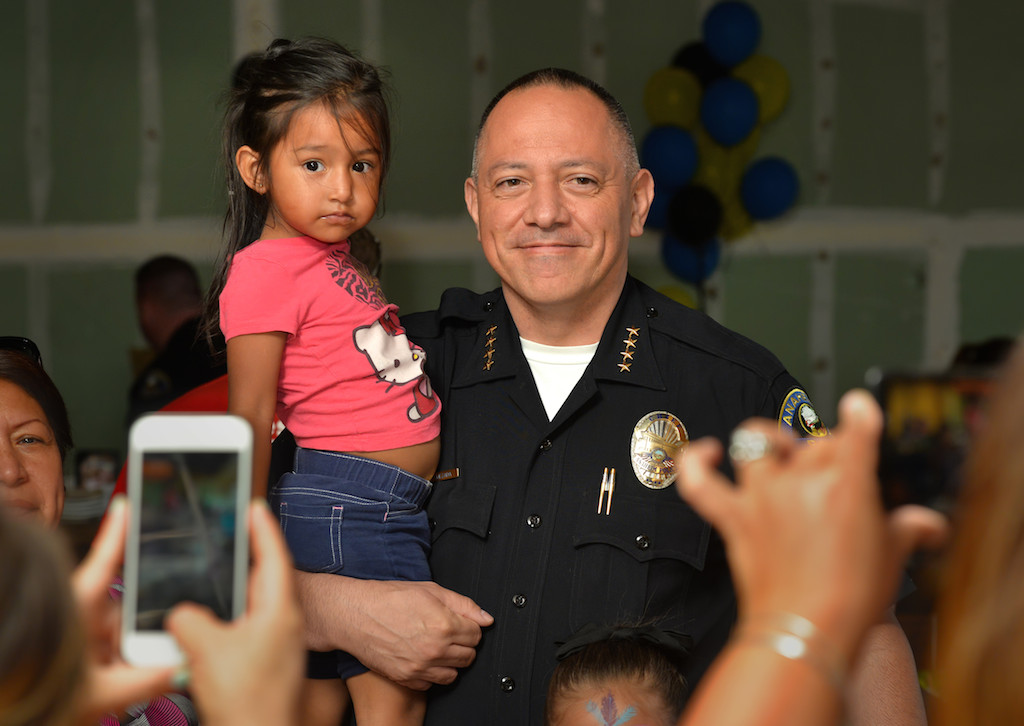 Six-year-old Samantha Sandoval of Anaheim has her photo taken with Anaheim Police Chief Raul Quezada during the Tip-A-Cop Tip-A-Cop fundraiser for Anaheim PD’s Cops for Kids. Photo by Steven Georges/Behind the Badge OC