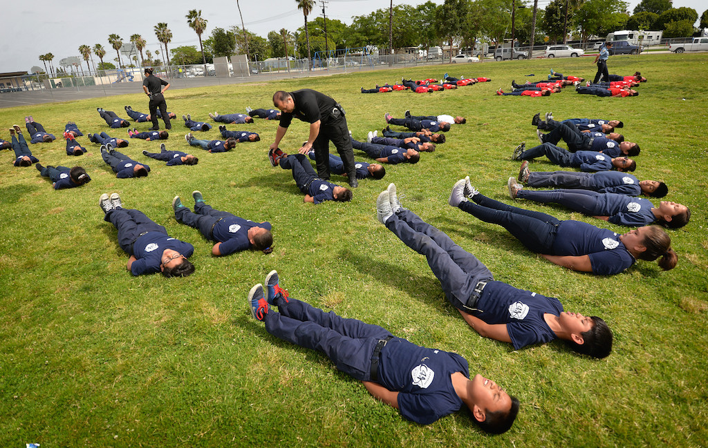 Anaheim Police Sgt. Jake Gallacher helps Jr. Cadets with their calisthenics during a Cops for Kids class at Paul Revere Elementary in Anaheim. Photo by Steven Georges/Behind the Badge OC