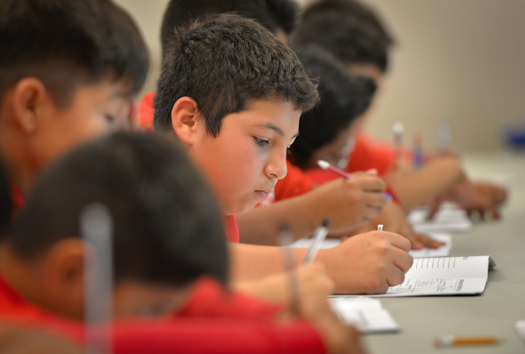 Eleven-year-old Venny Herrera takes notes on the subject of 911 calls during a Cops for Kids class at Paul Revere Elementary in Anaheim. Photo by Steven Georges/Behind the Badge OC