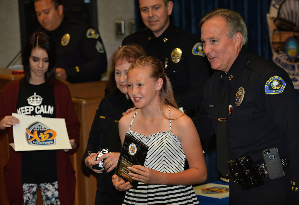 Scarlett Smith, 6th grade of Salk Elementary, receives an award for Outstanding Achievement and Exemplary Behavior during the Do the Right Thing awards ceremony at the Anaheim police headquarters. Photo by Steven Georges/Behind the Badge OC
