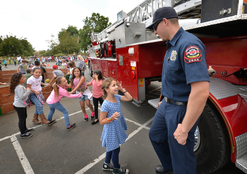 Firefighter Chris Goedl of the Fullerton Fire Department talks to kids at Rolling Hills Elementary School in front of Fullerton Fire Truck 1 during the Team Kids Challenge Carnival benefiting cystic fibrosis research and education. Photo by Steven Georges/Behind the Badge OC