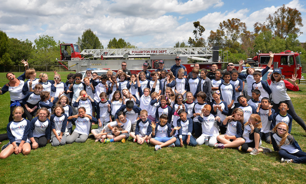 Kids from Rolling Hills Elementary in Fullerton and organizers have their photo taken with Fullerton police and fire personal after the Team Kids Challenge Carnival benefiting cystic fibrosis research and education. Photo by Steven Georges/Behind the Badge OC