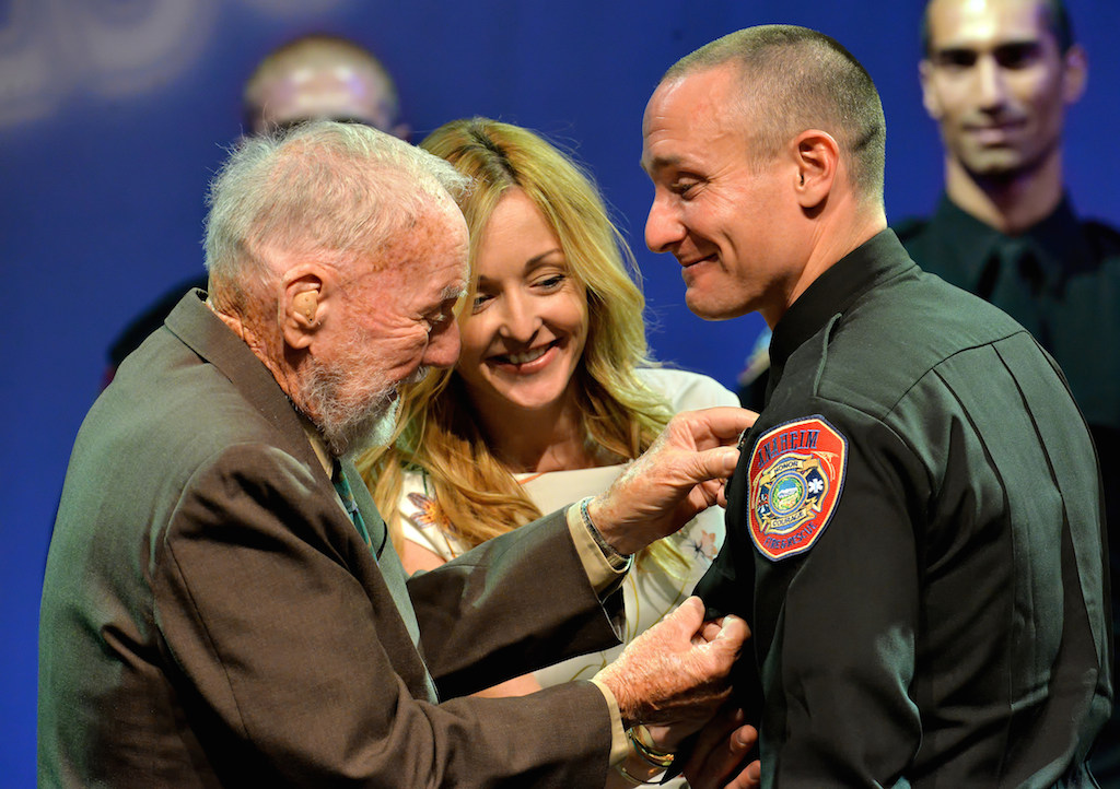 Anaheim Firefighter Sean Mazza receives his badge from his grandfather James Millard and his girlfriend Brittany Boole during the Anaheim Fire & Rescue Promotion and Graduation ceremony. Photo by Steven Georges/Behind the Badge OC