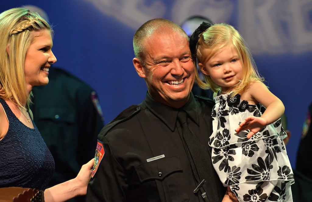 Anaheim Firefighter Jason Buchanan’s daughter waves to the crowd after her father received his badge during the Anaheim Fire & Rescue Promotion and Graduation ceremony. Jason’s wife Rebecca is left. Photo by Steven Georges/Behind the Badge OC