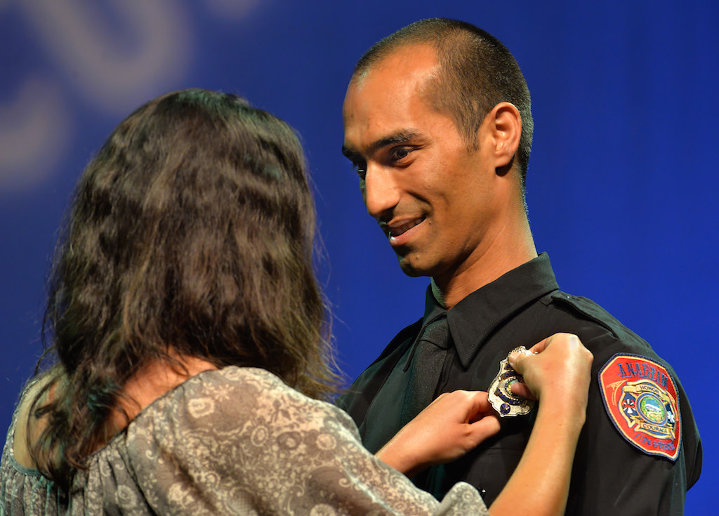 Anaheim Firefighter Sean Salimian receives his badge from his fiance Sara Balbas during the Anaheim Fire & Rescue Promotion and Graduation ceremony. Photo by Steven Georges/Behind the Badge OC
