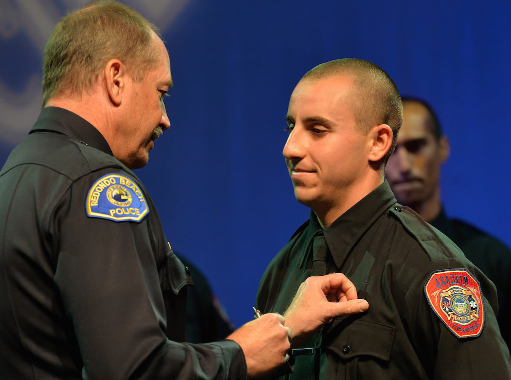 Anaheim Firefighter Jonathon Neu receives his badge from his father, Redondo Beach Police Chief John Neu, during the Anaheim Fire & Rescue Promotion and Graduation ceremony. Photo by Steven Georges/Behind the Badge OC