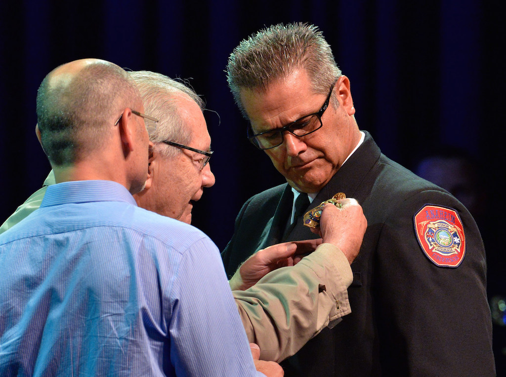 Jeff Alario receives his deputy chief badge from his father, Ed Alario during the Anaheim Fire & Rescue Promotion and Graduation ceremony. Photo by Steven Georges/Behind the Badge OC