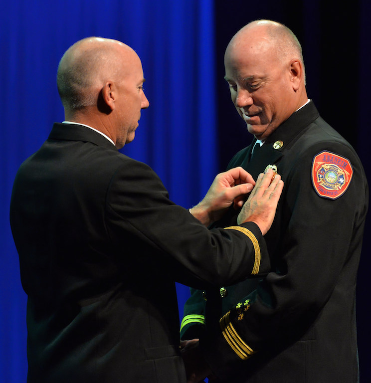 Jeff Thomas receives his battalion chief badge from his twin brother, Orange City Battalion Chief Jack Thomas during the Anaheim Fire & Rescue Promotion and Graduation ceremony. Photo by Steven Georges/Behind the Badge OC