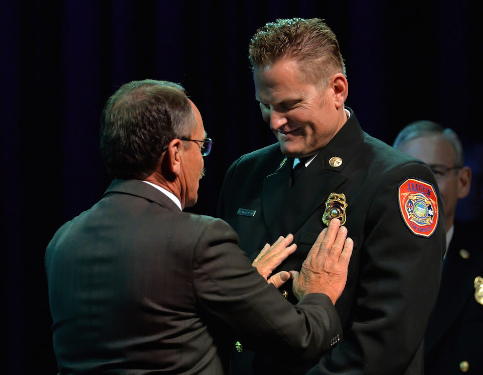Robert Mcclellan receives his battalion chief badge from his father Dirk Mcclellan, a retired fire captain from the Los Angeles County Fire Department, during the Anaheim Fire & Rescue Promotion and Graduation ceremony. Photo by Steven Georges/Behind the Badge OC