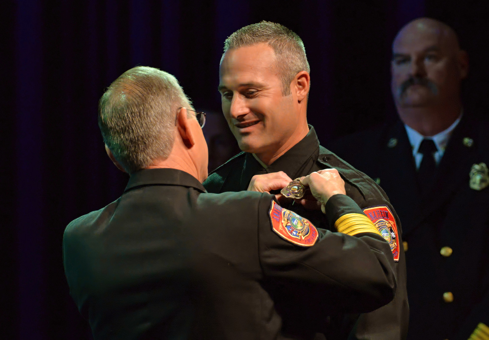 Fire Engineer Chris Fulkerson receives his new badge from Fire Chief Randy Bruegman during the Anaheim Fire & Rescue Promotion and Graduation ceremony. Photo by Steven Georges/Behind the Badge OC
