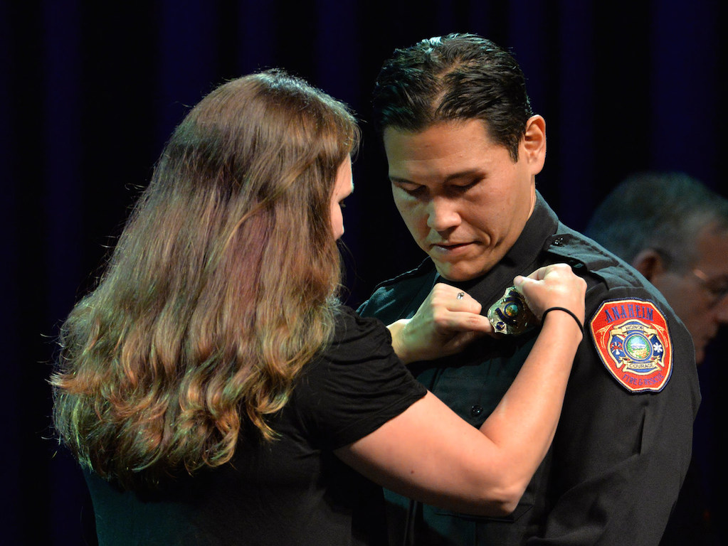 Fire Engineer David Reeves receives his new badge from his wife Rebecca Reeves during the Anaheim Fire & Rescue Promotion and Graduation ceremony. Photo by Steven Georges/Behind the Badge OC