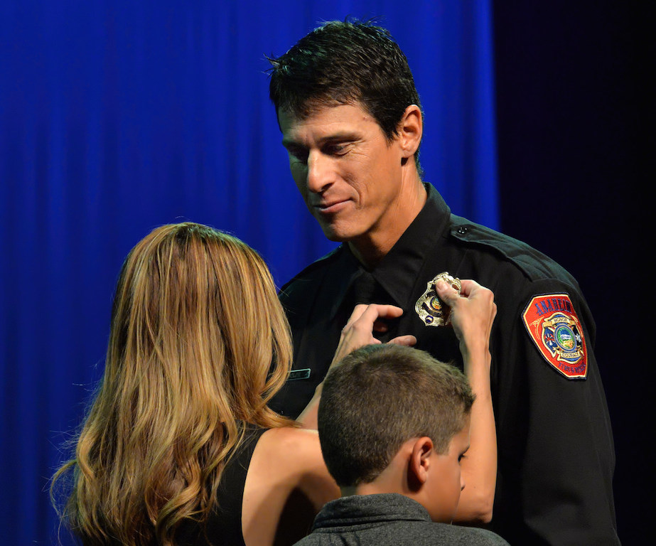 Fire Engineer Kevin Volpe receives his new badge from his wife Tiffany Vo during the Anaheim Fire & Rescue Promotion and Graduation ceremony. Photo by Steven Georges/Behind the Badge OC