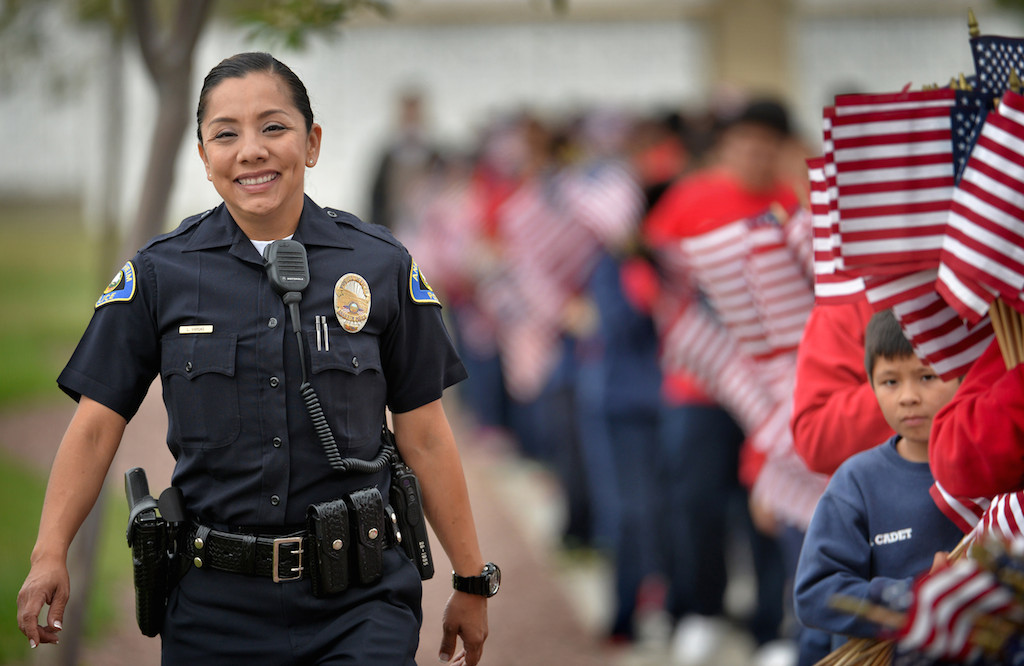 Officer Leslie Vargas of Anaheim PD helps lead Anaheim PD Explorers and Jr. Cadets to the next location at Riverside National Cemetery to place American flags next to gravesites for Memorial Day weekend. Photo by Steven Georges/Behind the Badge OC
