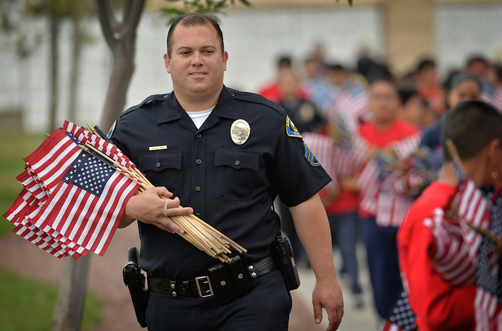 Anaheim Police Sgt. Jake Gallacher leads Anaheim PD Explorers and Jr. Cadets to the next location at Riverside National Cemetery to place American flags next to gravesites for Memorial Day weekend. Photo by Steven Georges/Behind the Badge OC