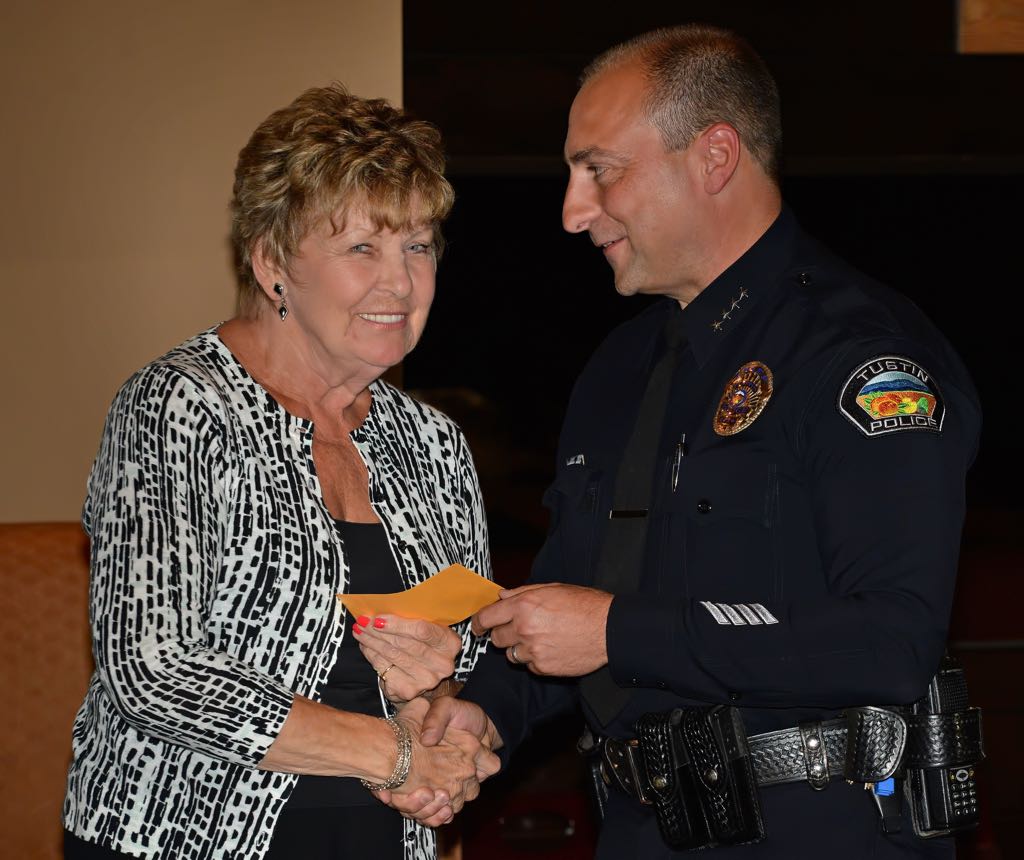Volunteer Marilyn Hogan receives a pin from Tustin Police Chief Charles Celano for 7000 hours of work during Tustin PD’s annual volunteer appreciation awards dinner. Photo by Steven Georges/Behind the Badge OC