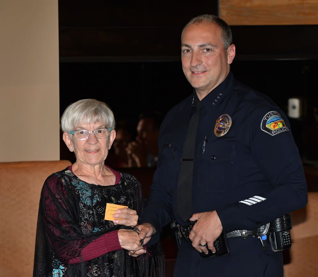 Volunteer Diane D’Arcy receives a pin from Tustin Police Chief Charles Celano for 2500 hours of work during Tustin PD’s annual volunteer appreciation awards dinner. Photo by Steven Georges/Behind the Badge OC