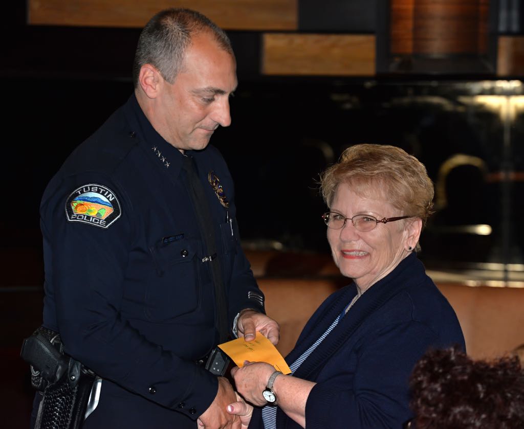 Tustin Police Chief Charles Celano presents volunteer Salli Kelly a pin for 500 hours of work during Tustin PD’s annual volunteer appreciation awards dinner. Photo by Steven Georges/Behind the Badge OC