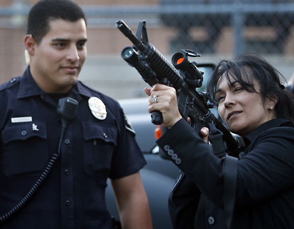 La Habra Police Department SWAT Officer Ricardo Rodriguez instructs Julie Cruz in the use of a Colt M4 rifle during a demonstration for the La Habra Citizen's Police Academy.    Photo by Christine Cotter/Behind the Badge OC