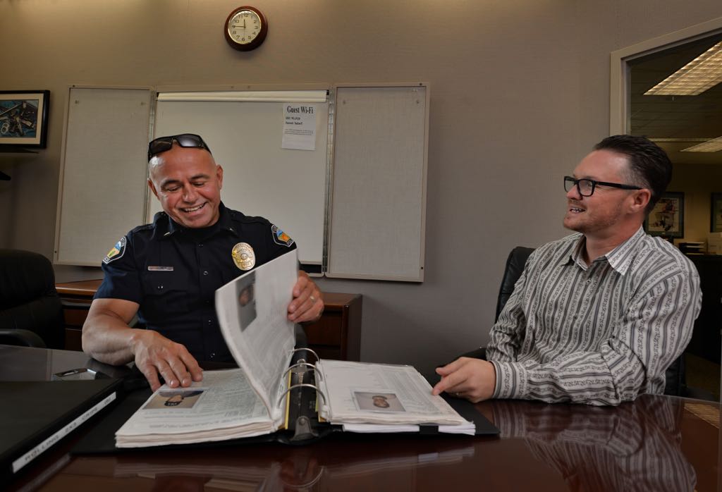 Lt. Jeff Blair of the Tustin PD goes over old stories with former gang member Jimmy Rumsey as they thumb through old gang files and what has become of various gang members they use to deal with. Photo by Steven Georges/Behind the Badge OC