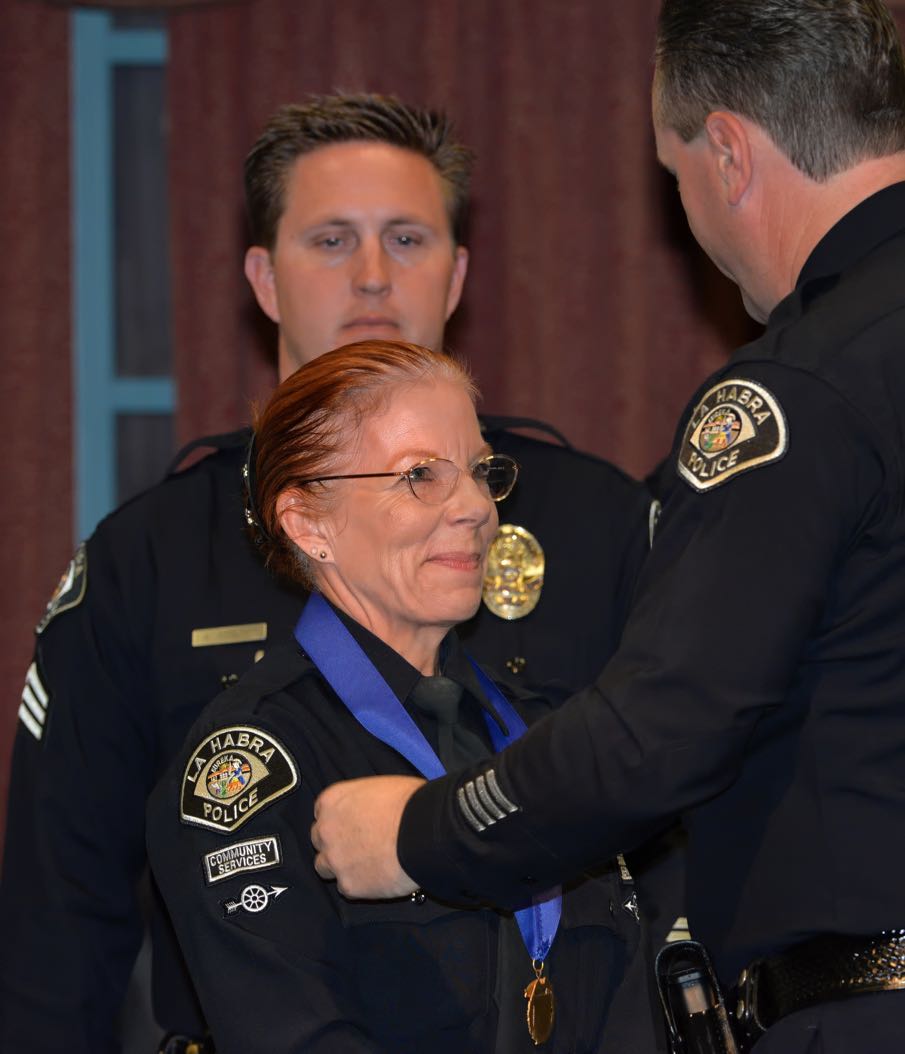 Community Service Officer Christina Nuñez receives a Career Service Medal for 20 years of Service from La Habra Police Chief Jerry Price during the La Habra Police Department Awards & Commendations Ceremony. Photo by Steven Georges/Behind the Badge OC