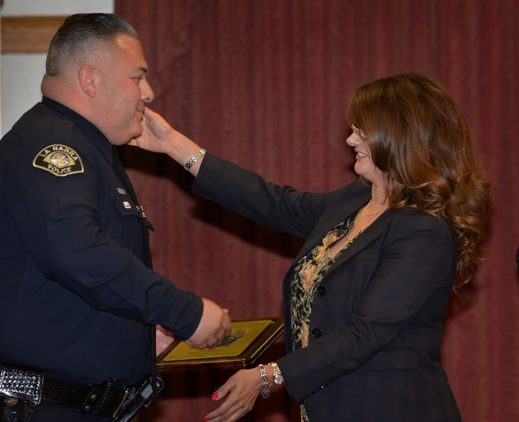Officer Jason Sanchez receives a hug as he is awarded the 2014 Osornio Award for “Excellence in Drunk Driver Detection and Apprehension” during the La Habra Police Department Awards & Commendations Ceremony. Photo by Steven Georges/Behind the Badge OC