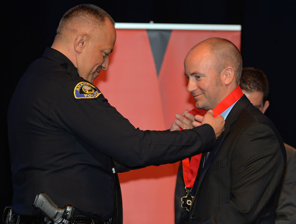 Officer Brian Snowden receives the Distinguished Service medal for “fast reaction and quick thinking during an armed felony car stop” from Anaheim Police Chief Raul Quezada during Anaheim PD’s 2015 Awards and Retirement Ceremony. Photo by Steven Georges/Behind the Badge OC