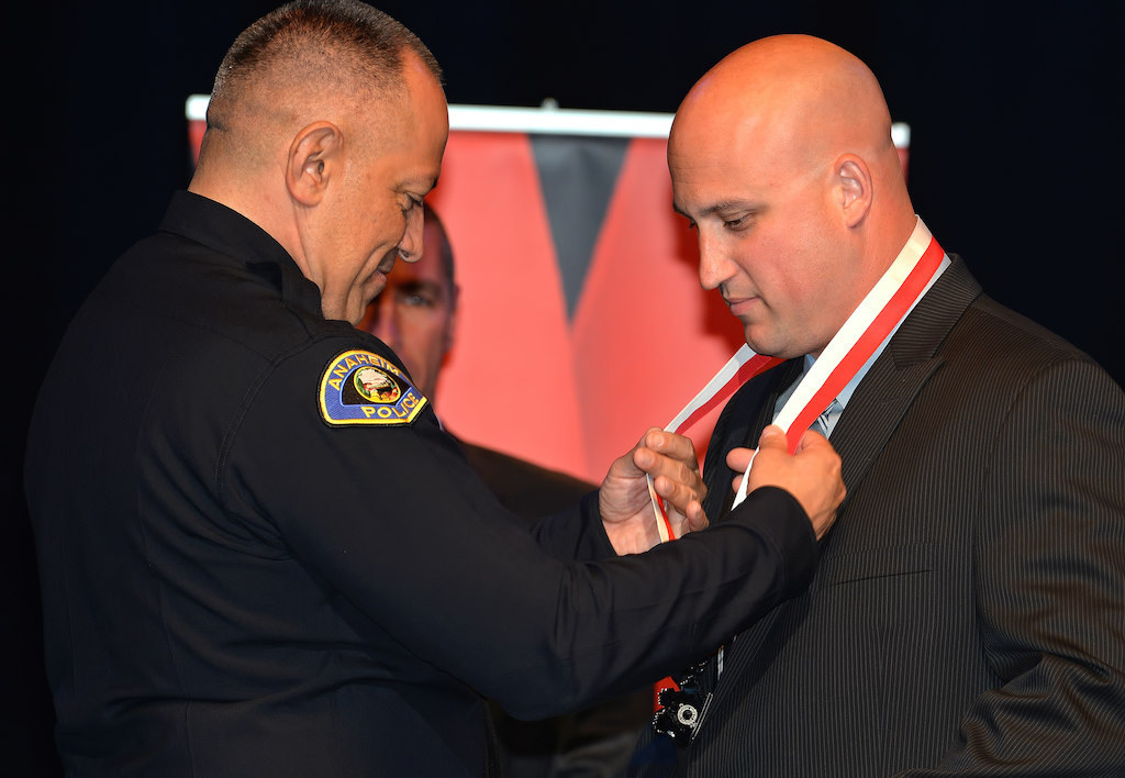 Officer Ted Petropulos receives a Lifesaving Medal “for quick actions and immediate lifesaving efforts that saved a 5-year-old girl’ from Anaheim Police Chief Raul Quezada during Anaheim PD’s 2015 Awards and Retirement Ceremony. Photo by Steven Georges/Behind the Badge OC
