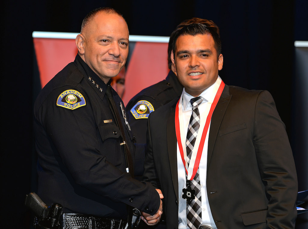 Officer Jose Duran, right, receives a Lifesaving Medal “for quick actions and immediate lifesaving efforts that saved a 5-year-old girl’ from Anaheim Police Chief Raul Quezada during Anaheim PD’s 2015 Awards and Retirement Ceremony. Photo by Steven Georges/Behind the Badge OC
