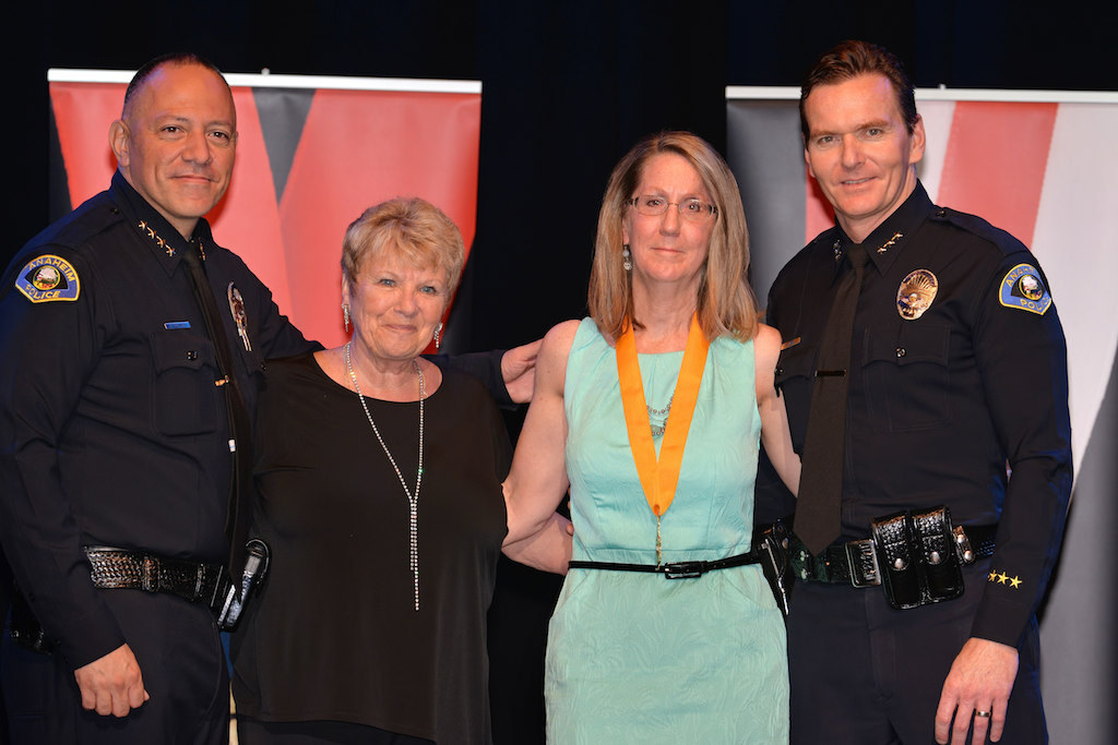 Records Manager Barbara Nail (right) with Anaheim Police Chief Raul Quezada, left, and Anaheim Deputy Chief Julian Harvey, right, after receiving her Career Achievement medal for 30 years of service. Photo by Steven Georges/Behind the Badge OC