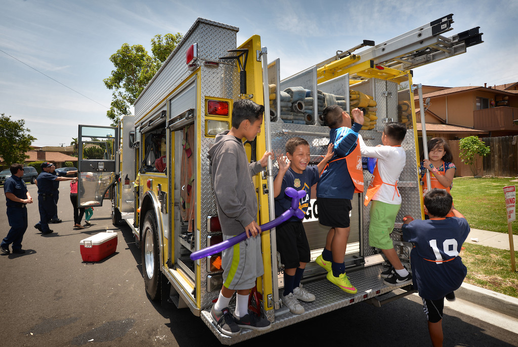 Neighborhood kids get a chance to play and explore on the back of Garden Grove Engine 6 during a community gathering along Laguna Street in Garden Grove. Photo by Steven Georges/Behind the Badge OC