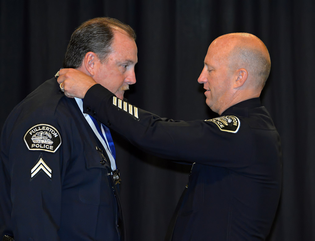 Corporal Mike Bova receives the Life Saving Medal from Chief Dan Hughes during Fullerton PD’s Promotions and Awards Ceremony for his role in saving a 1-year-old baby who had fallen in the pool and stopped breathing. Photo by Steven Georges/Behind the Badge OC