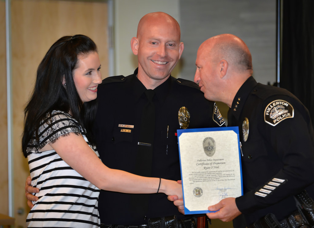 Ryan O’Neil, center, with his wife Kathleen, receives his promotion certificate and badge with the rank of Corporal from Chief Dan Hughes during Fullerton PD’s Promotions and Awards Ceremony. Photo by Steven Georges/Behind the Badge OC