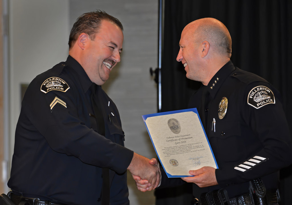 Gary Sirin smiles as he receives a promotion certificate to the rank of Corporal from Chief Dan Hughes during Fullerton PD’s Promotions and Awards Ceremony. Photo by Steven Georges/Behind the Badge OC