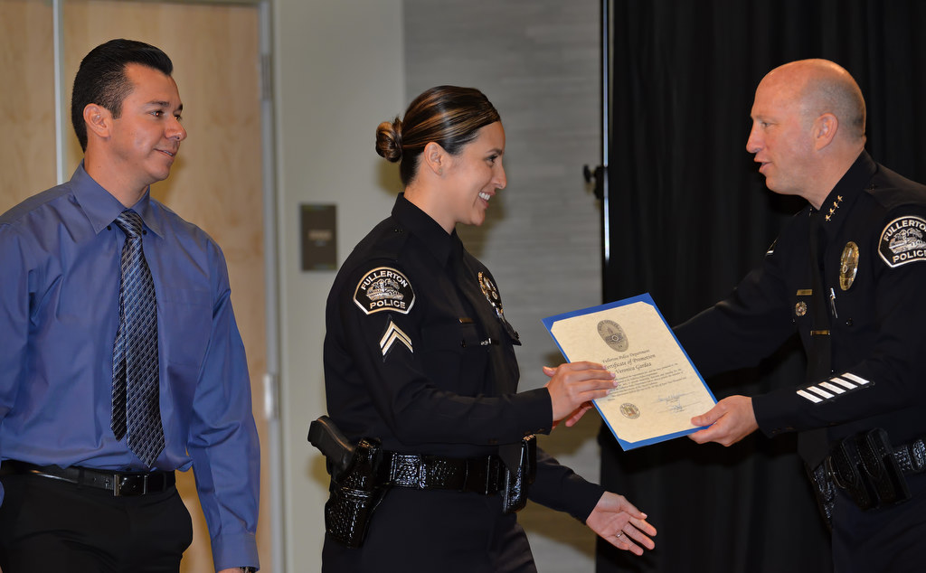 Veronica Gardea, center, receives a promotion certificate to the rank of Corporal from Chief Dan Hughes during Fullerton PD’s Promotions and Awards Ceremony. Veronica husband Eric is with her, left. Photo by Steven Georges/Behind the Badge OC