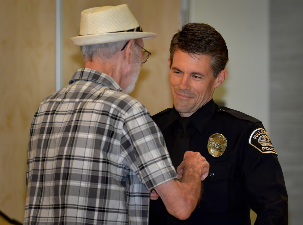 Chad Keen, who returns to the Fullerton PD from the State of Florida where he worked as a police officer and a deputy sheriff, receives his police officer badge from his uncle Vernon during Fullerton PD’s Promotions and Awards Ceremony. Photo by Steven Georges/Behind the Badge OC