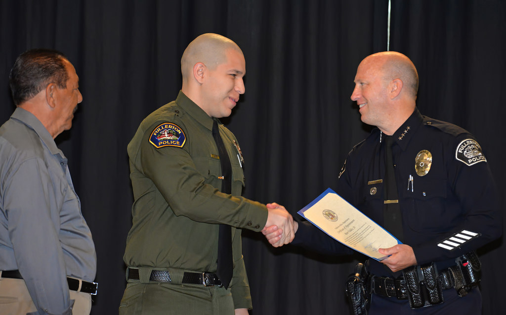 Rene Valdes, Jr., center, receivers his promotion certificate for full-time jailer from Chief Dan Hughes during Fullerton PD’s Promotions and Awards Ceremony. His father, Rene Sr., left, came up to pin him. Photo by Steven Georges/Behind the Badge OC