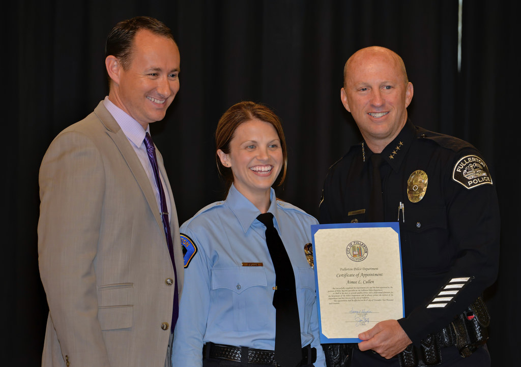 Aimee Cullen, center, receives her certificate of appointment for promotion to Police Records Specialist from Chief Dan Hughes during Fullerton PD’s Promotions and Awards Ceremony. Aimee’s husband Trevor Cullen, left, pinned her for the ceremony. Photo by Steven Georges/Behind the Badge OC