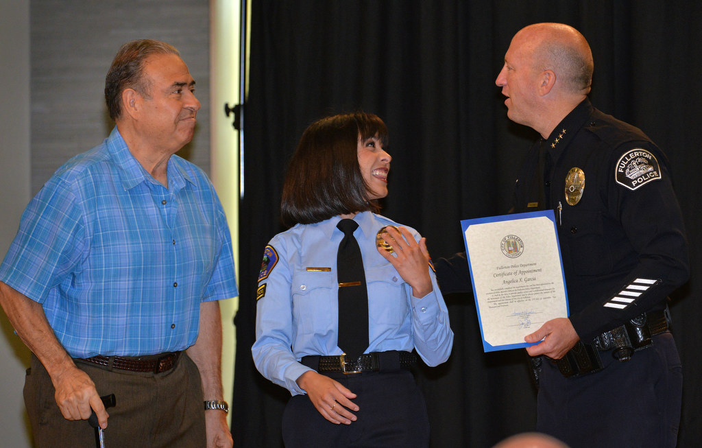 Angelica Garcia, who holds a Bachelor’s in Sociology from UC Santa Barbara, center, receives her appointment certificate for the position of Police Records Clerk from Chief Dan Hughes during Fullerton PD’s Promotions and Awards Ceremony. Photo by Steven Georges/Behind the Badge OC