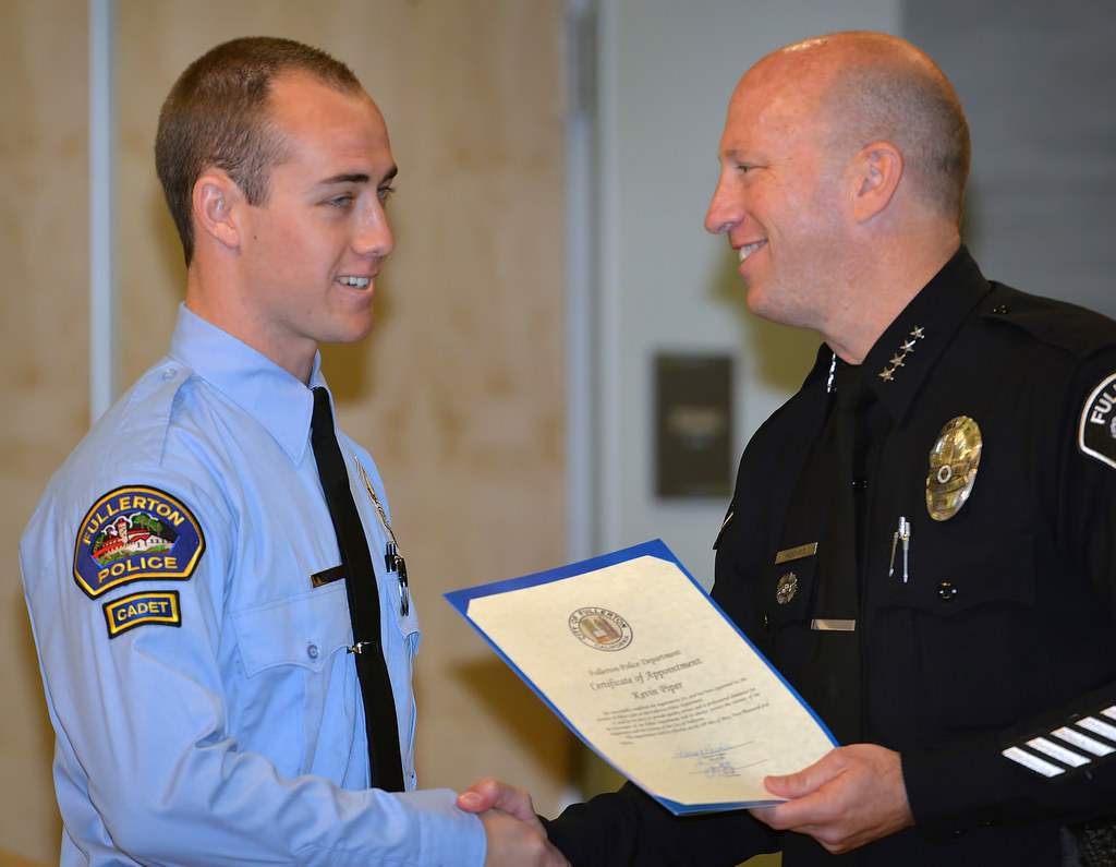 Kevin Piper, who is currently attending Fullerton College studying the Administration of Justice, receives his appointment certificate for the position of Fullerton Police Cadet from Chief Dan Hughes during Fullerton PD’s Promotions and Awards Ceremony. Photo by Steven Georges/Behind the Badge OC