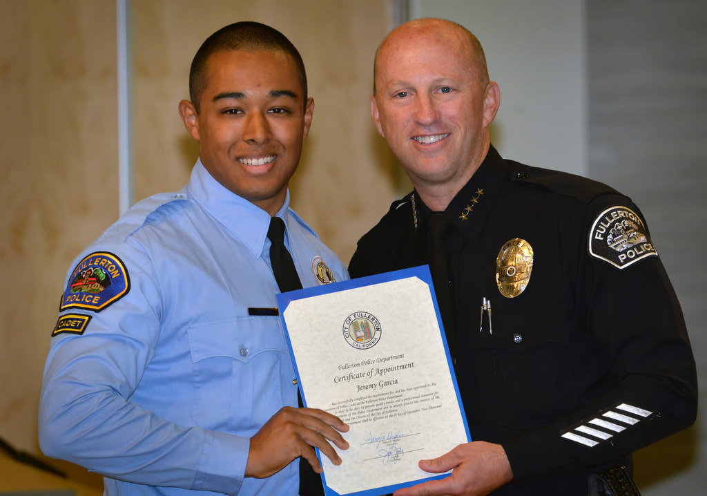 Jeremy Garcia, who is a sophomore at Cal State Fullerton pursuing his studies in Political Science, receives his appointment certificate for the position of Fullerton Police Cadet from Chief Dan Hughes during Fullerton PD’s Promotions and Awards Ceremony. Photo by Steven Georges/Behind the Badge OC