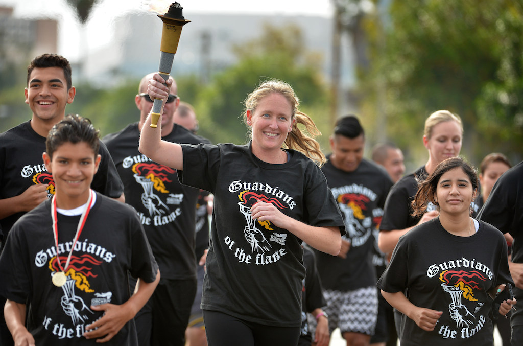 Kari Flood of the Garden Grove PD runs with the GGPD team down Chapman Ave. during the Law Enforcement Torch Run for Special Olympics. Photo by Steven Georges/Behind the Badge OC