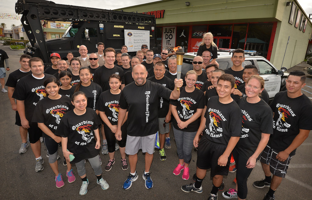 Teams from Anaheim PD and Garden Grove PD gather as Garden Grove hands the torch to Anaheim during the Law Enforcement Torch Run for Special Olympics. Photo by Steven Georges/Behind the Badge OC