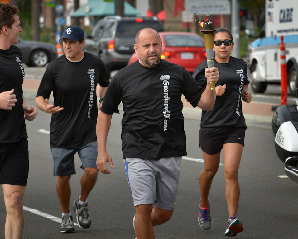 The Anaheim PD team runs with the torch up Harbor Blvd. during the Law Enforcement Torch Run for Special Olympics. Photo by Steven Georges/Behind the Badge OC