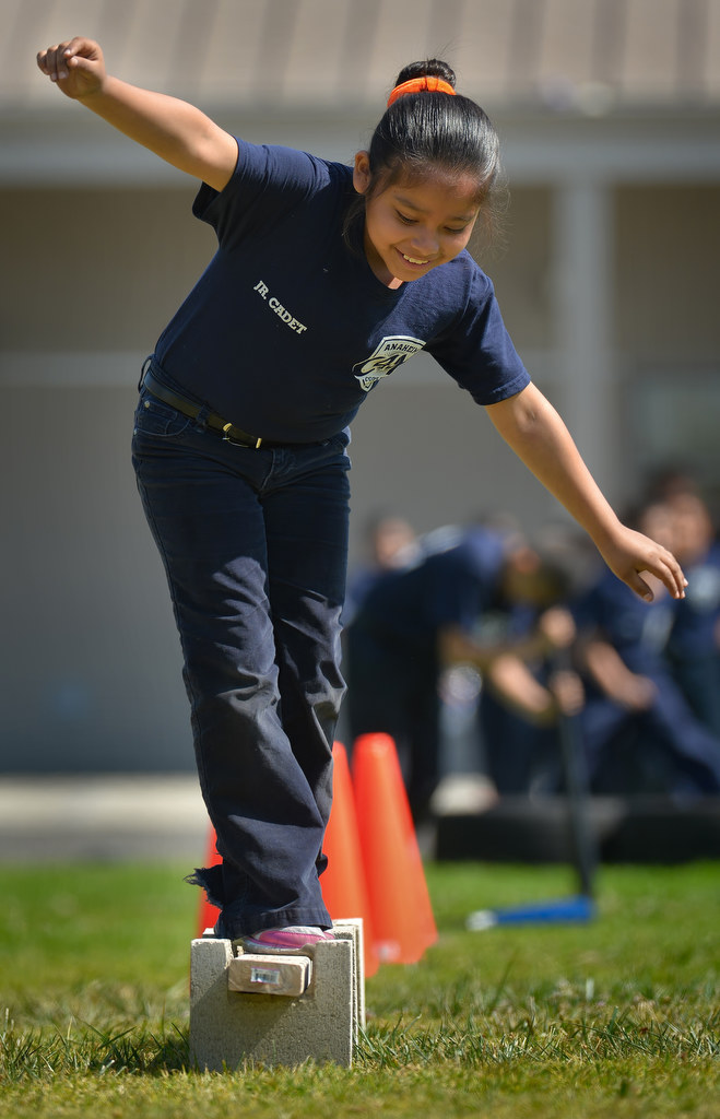 Junior cadet Nayeli Gutierrez tries to balance after spinning using a baseball bat for an obstacle course during Anaheim PDÕs Cops 4 Kids Jr. Cadet Academy at Betsy Ross Elementary. Photo by Steven Georges/Behind the Badge OC