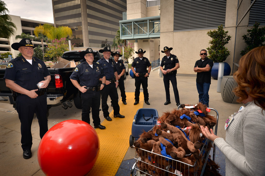 Anaheim Police Chief Raul Quezada, left, gathers with his posse outside the CHOC building as they get ready to visit kids and hand out Anaheim Police Mounted Unit toy horses. Photo by Steven Georges/Behind the Badge OC