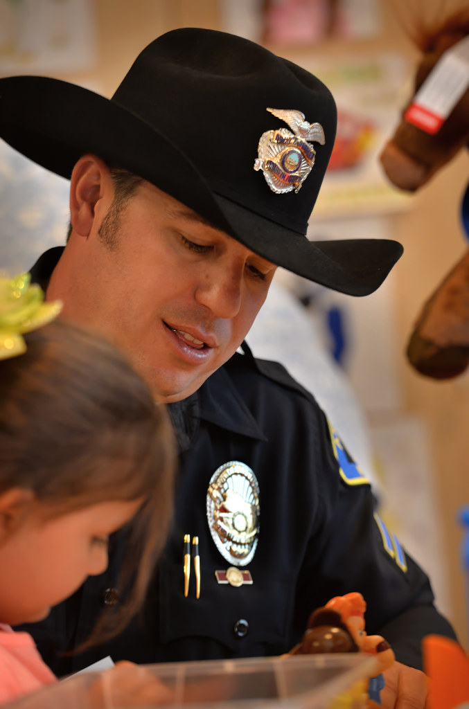 Anaheim Police Officer Eric Anderson spends a little time playing with 6-year-old Amelia Smith during a visit to CHOC. Photo by Steven Georges/Behind the Badge OC